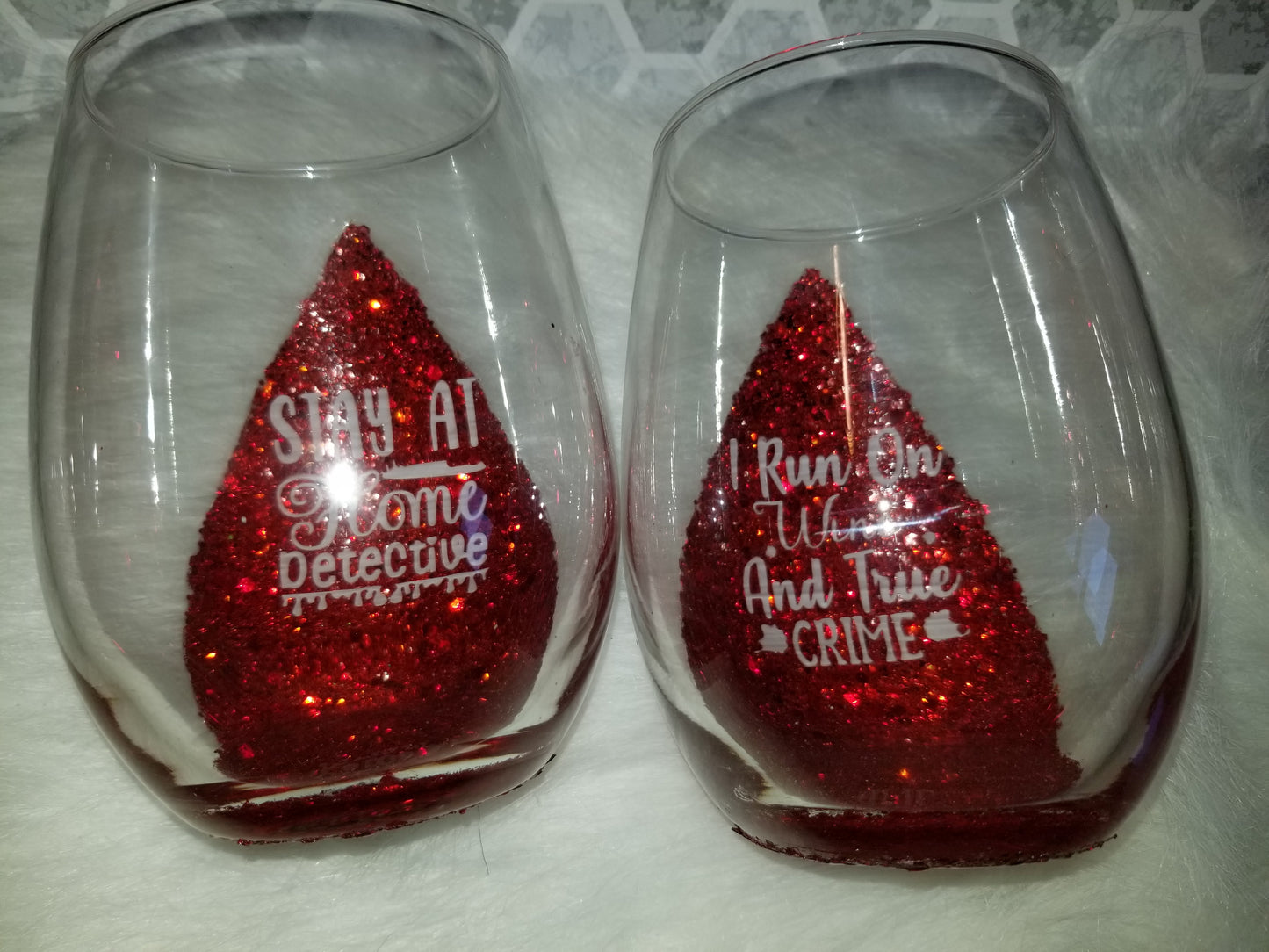 Set of 2-stemless wine glasses run on wine & true crime and stay at home detective quotes.