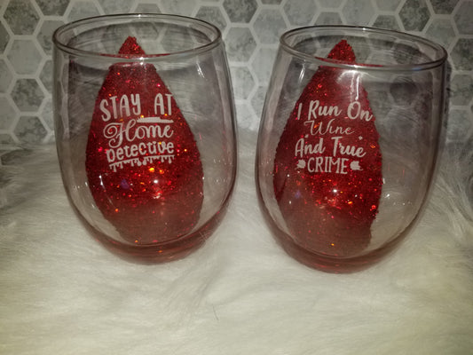 Set of 2-stemless wine glasses run on wine & true crime and stay at home detective quotes.